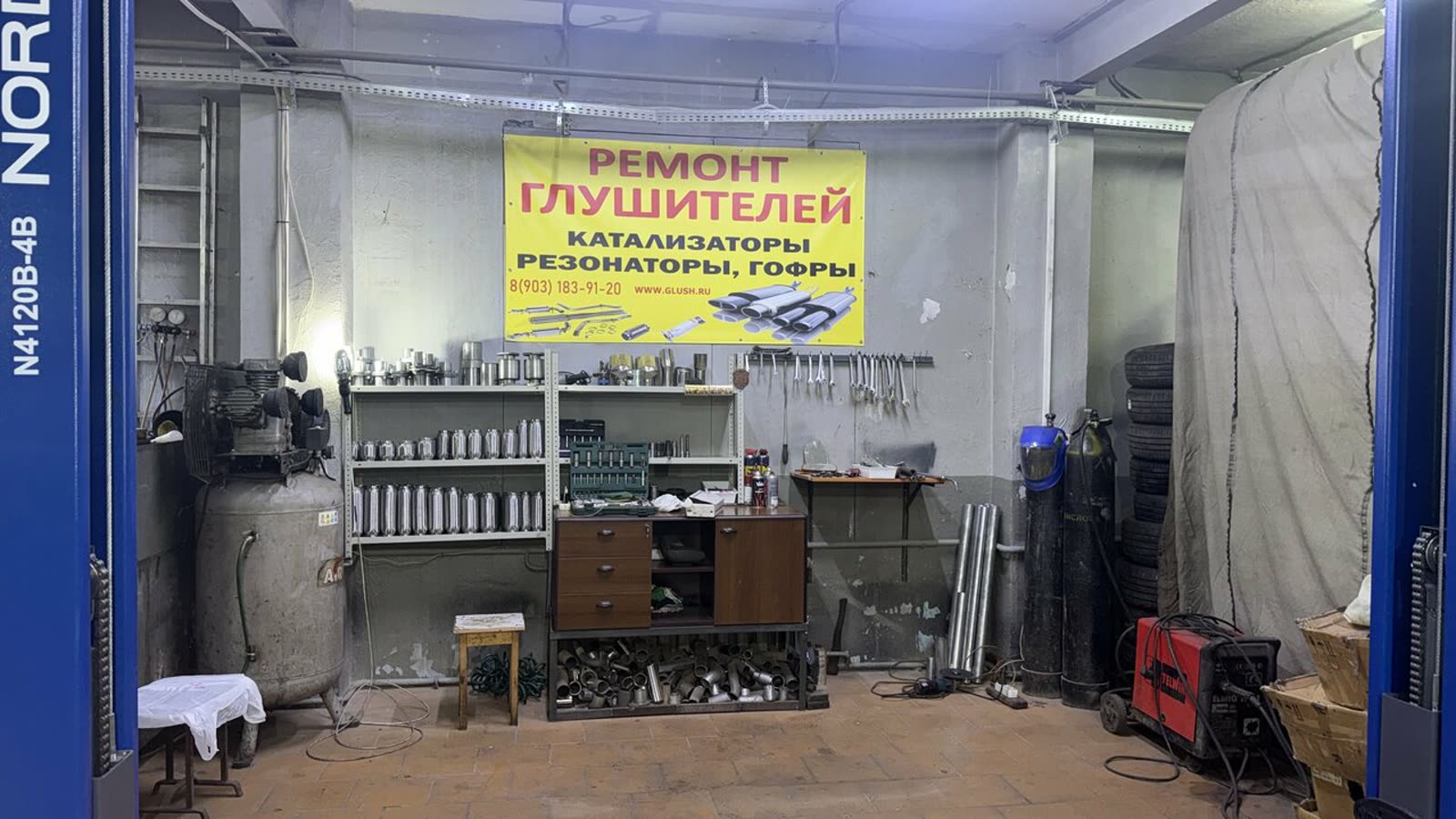 Цех: подъёмник и стеллажи с глушителями